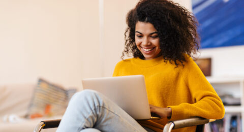 Image,Of,Cheerful,African,American,Woman,Using,Laptop,While,Sitting